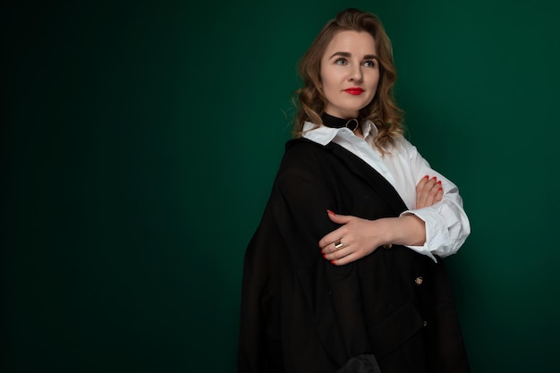 Woman standing with arms crossed against green background