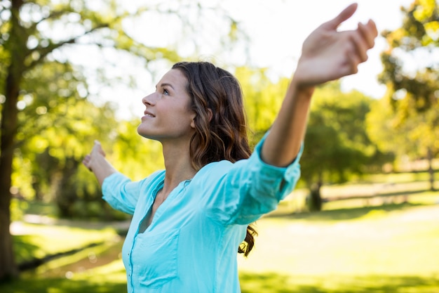 Woman standing with arms outstretched in park