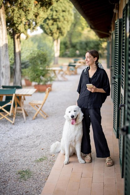 Woman standing with dog and looking away near entrance to hotel room