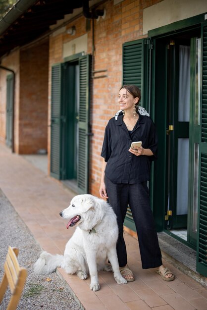 Woman standing with dog and looking away near entrance to hotel room