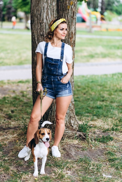 Woman standing with a dog outdoor . 