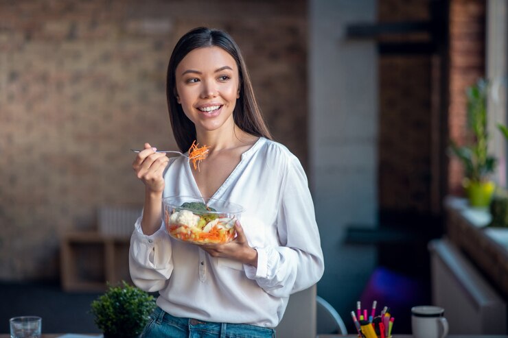Photo woman standing with her salad while having lunch