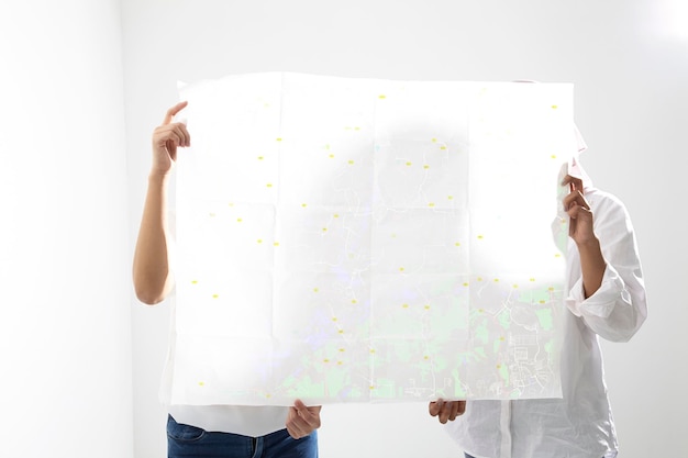 Photo woman standing with large paper against white wall