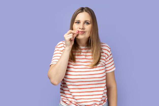 Woman standing and zipping her mouth knows secret does not tell to anyone