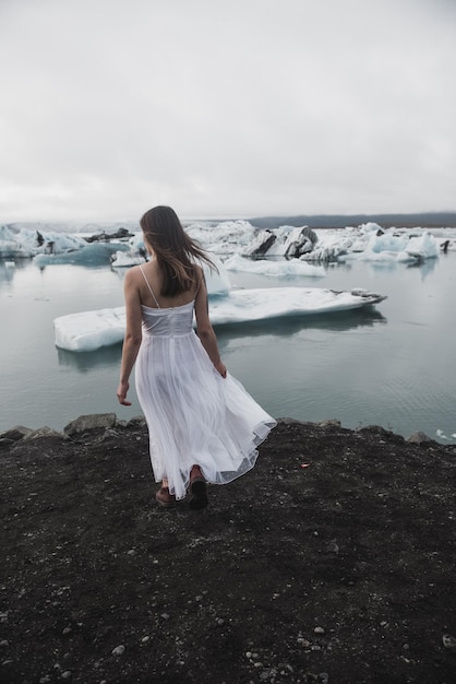 Woman stands against the background of glaciers in Iceland