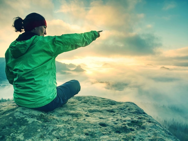 Photo woman stands alone on edge colorful mist in valley silhouette scene