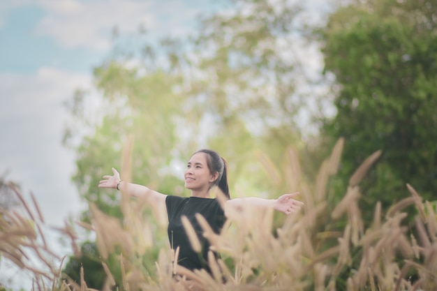 Woman stands in a beautiful meadow forest in a relaxing atmosphere with nature.