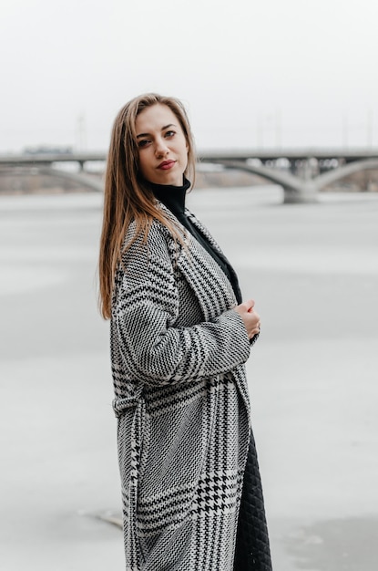 A woman stands by a frozen river