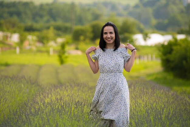 A woman stands in a field of lavender.