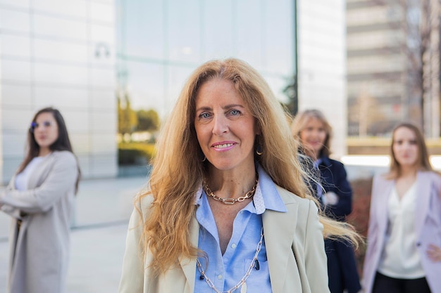 A woman stands in front of a building with a building in the background.