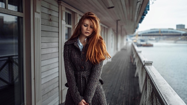 a woman stands in front of a building with a red hair