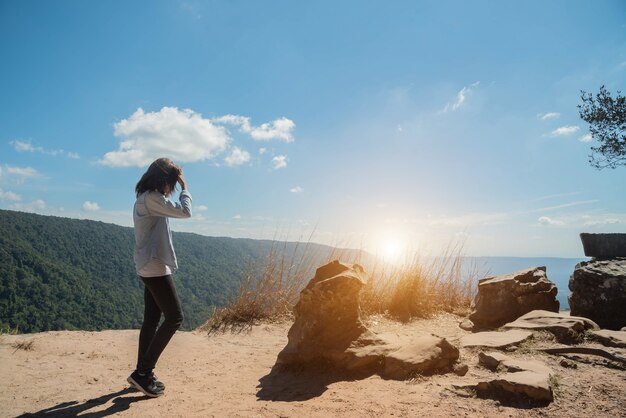 女性は太陽の光のためにマウンテンビューで空に立っています