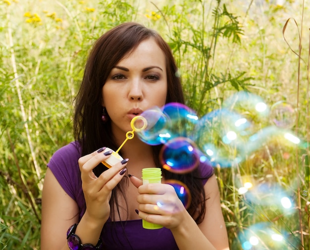 Photo woman  starts soap bubbles