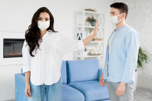 Foto donna che sta lontano dall'uomo con la maschera