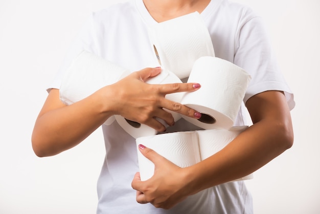 Woman stocking up she holding many rolls of toilet paper in arms on chest