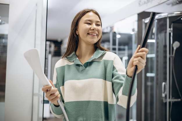 Woman in store choosing bath mixer