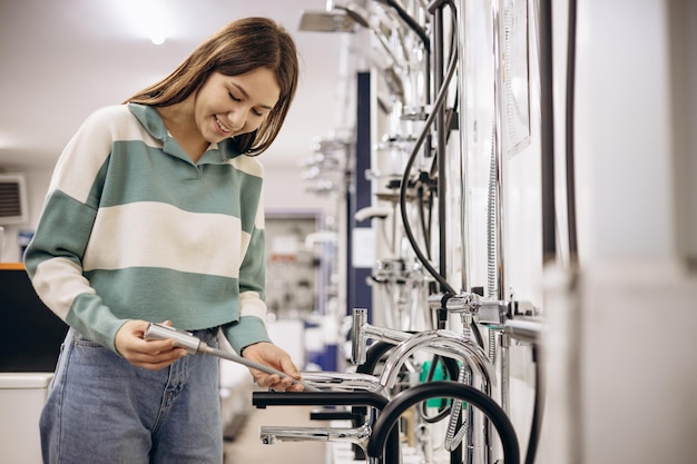 Woman in store choosing bath mixer