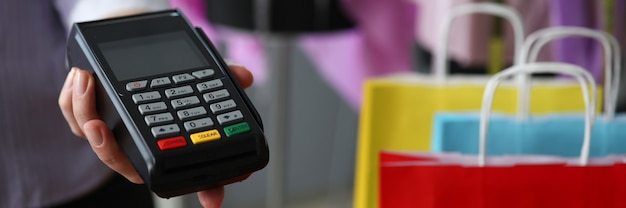 Woman at store holds out customer pos terminal