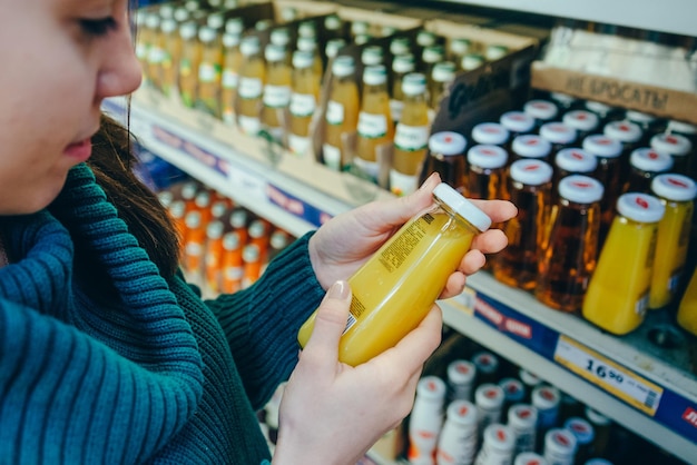 woman in store read ingredients of juice grocery shopping copy