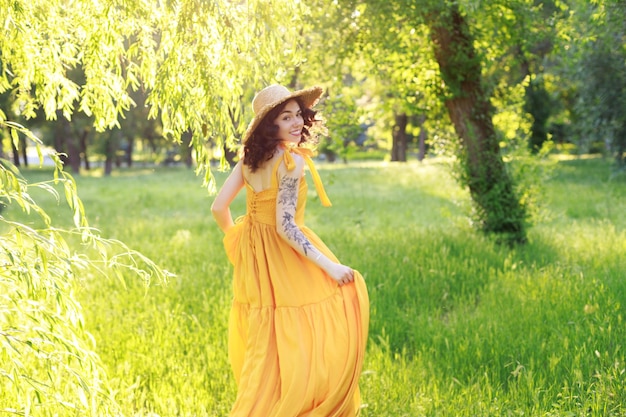 A woman in a straw hat runs away in the garden in the summer Blur