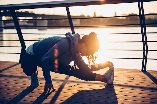 Foto donna che fa stretching lungo il fiume