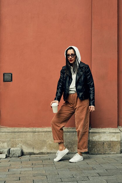 woman on the street with a disposable paper cup. Take away food, walk around the city.