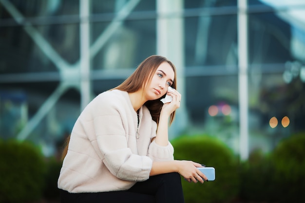 Woman stressed from work while sitting outdoors