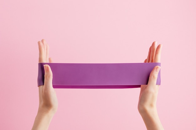 woman stretch fitness band. violet rubber for home exercises.