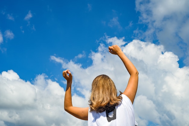 A woman stretches her hands to the sky