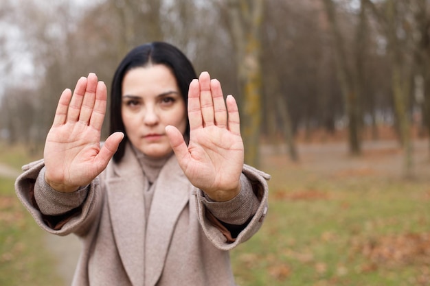 Woman stretches her hands with open palms as a stop sign