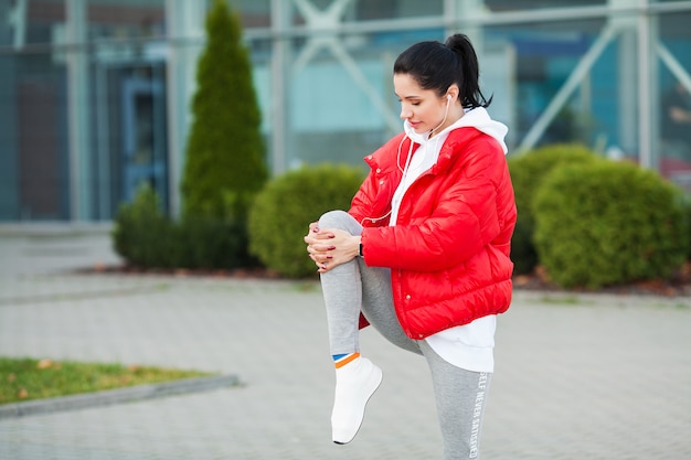 Photo woman stretching body, doing exercises on street