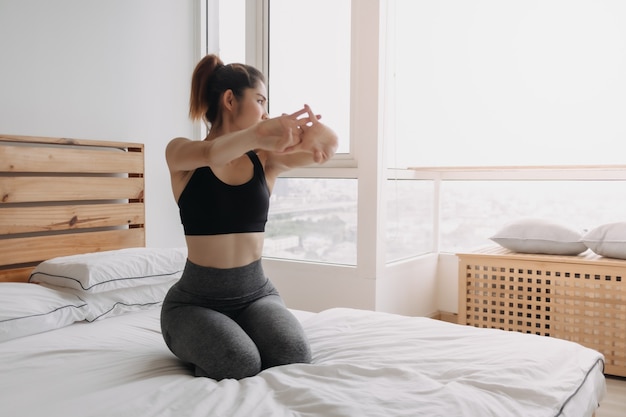 Woman stretching and cool down after workout in her apartment room