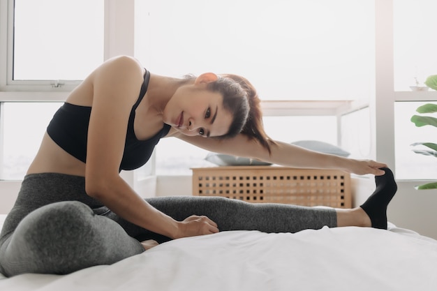 Woman stretching and cool down after workout in her apartment room