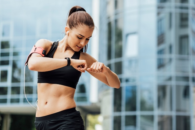 Photo woman stretching with glass building behind