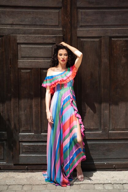 A woman in a striped dress stands in front of a door