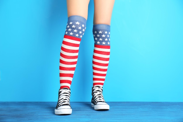 Woman in striped stockings on color background