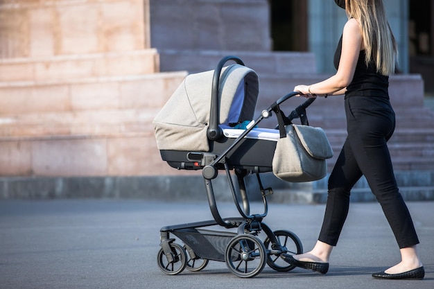 Photo woman and stroller in the street backgroundxa