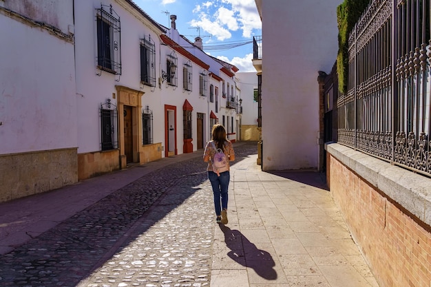 Женщина прогуливается по узким улочкам белых домов красивой андалузской деревни Ронда Малага