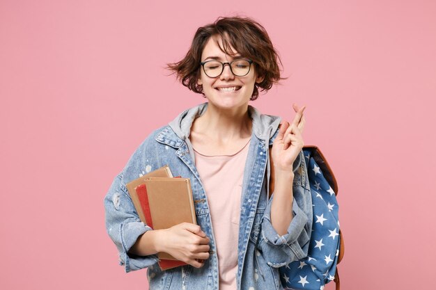 Woman student in denim clothes isolated on pink background education in high school university