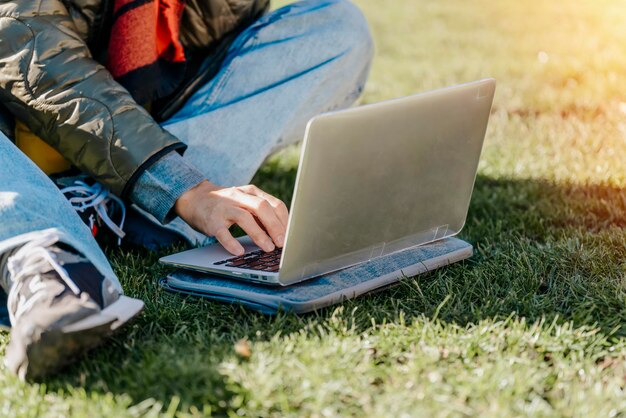 Woman student distance training course study working on the\
grass