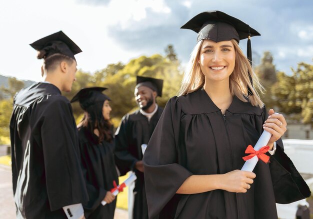 Sorriso di studentessa e ritratto per la cerimonia di laurea o il conseguimento nell'istruzione superiore felice studentessa accademica in possesso di certificato di qualificazione o laurea per borsa di studio universitaria