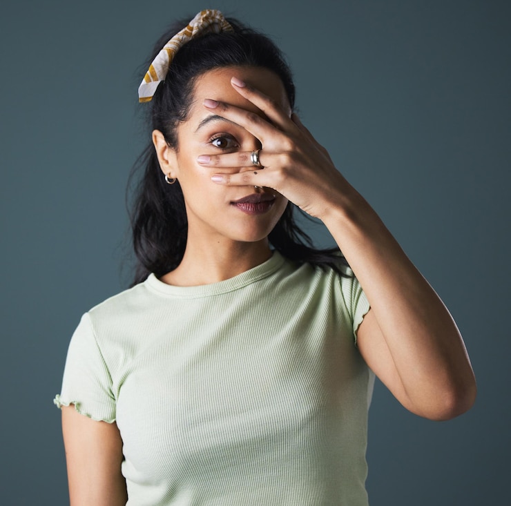 Photo woman studio and hide with hand peeking or spying portrait isolated on grey background model peeping or watching for secret suspect and curious with covered eye for shy or suspicious reaction