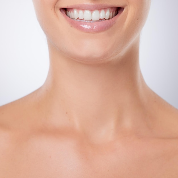 Woman studio and mouth for clean teeth whitening results and cosmetics on white background Female person oral hygiene and proud of orthodontics by dermatology dental health and invisible veneers