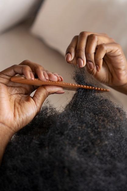 Woman styling afro hair with comb