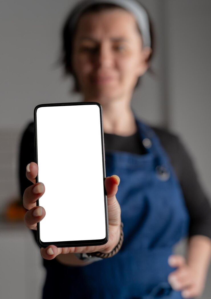 Woman in stylish forefront shows smartphone with white screen in closeup view