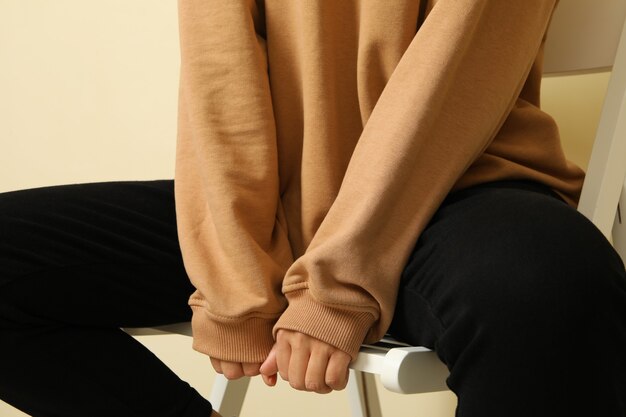 Woman in stylish sweatshirt sitting on chair