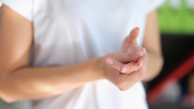 Woman suffering because pain in her joints close up female holding and massaging her hand