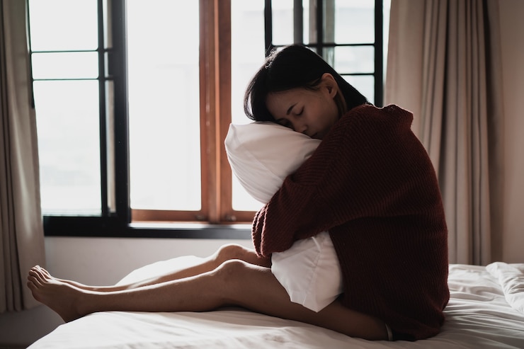 Photo 寝室のベッドに座ってうつ病に苦しんでいる女性