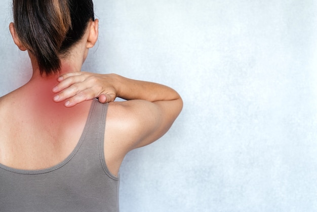 A woman suffering from neck pain and massaging her neck to releive pain, neck pain relief exercises