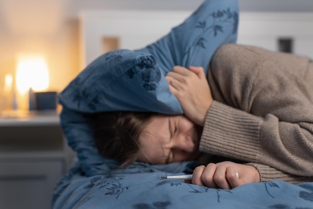 Женщина, страдающая от сильной головной боли или мигрени, простуды и гриппа, имеет температуру тепла